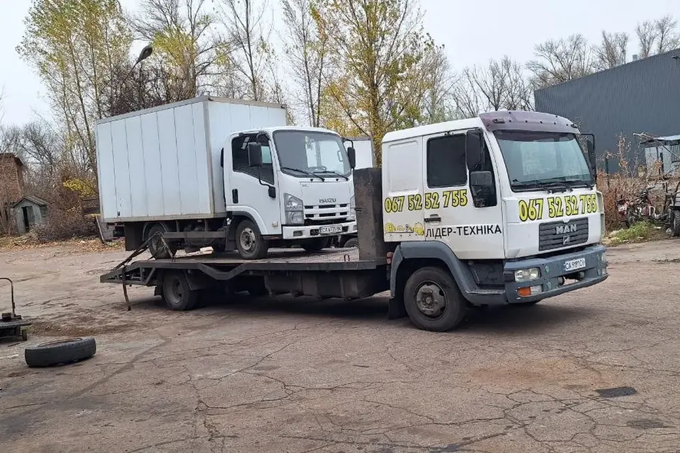 Евакуатор LIDER-T перевозить вантажний Isuzu на платформі